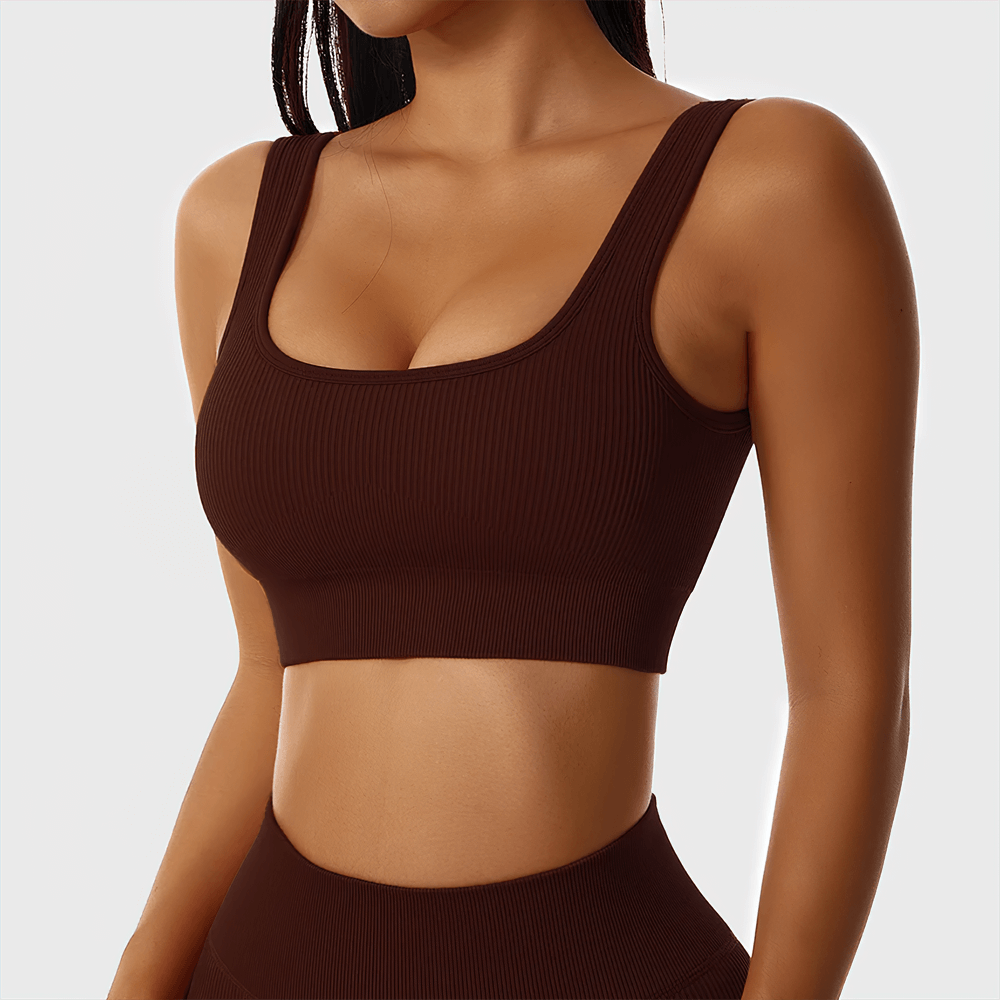 Woman wearing a seamless ribbed sports bra in brown, made from breathable nylon and spandex, perfect for yoga and fitness activities.